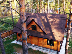 Красивый деревянный дом в лесу с мягкой черепицей